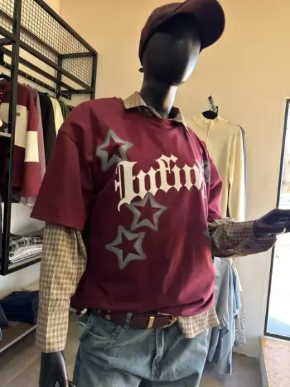 Maniquí en la vidriera de Rústica con remera bordó estampada y jean